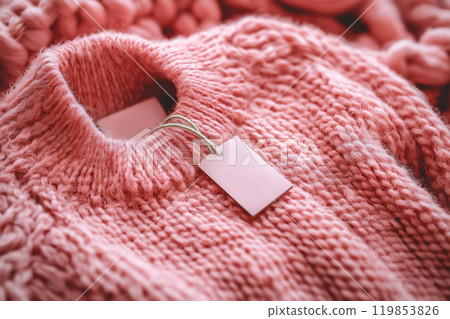 Pink wool sweater with an empty inner label on the neck. Blank laundry care clothes label on knitted fabric background, mockup, blank space to place text or brand logo, size and info patch on clothes 119853826
