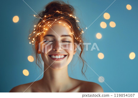 Happy young woman with glowing light strings around her head, a concept of mindfulness, meditation, creativity inspiration. Cozy home Christmas time, decorative Christmas twinkling string lights 119854107