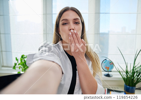 Close-up selfie portrait of young cheerful woman looking at web camera 119854226