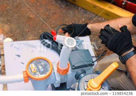 Assembling sand filter system tank and equipment for cleaning water in swimming pools by maintenance worker 119854236