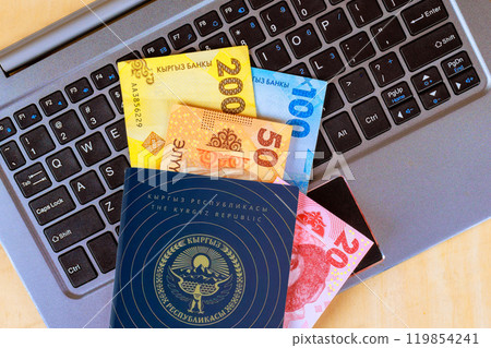 Money of various denominations from Kyrgyzstan over keyboard for payment online in Kyrgyz Republic passport 119854241