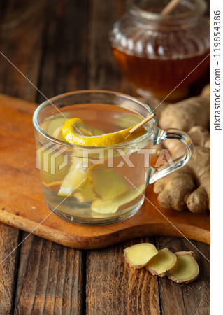 Ginger tea with lemon and honey on a old wooden table. 119854386