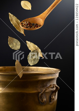 Mix of dried spices is poured into a old brass pan. 119854422