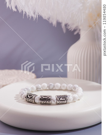 Woman's wrist wearing orange agate bracelet, isolated on white background. 119854480