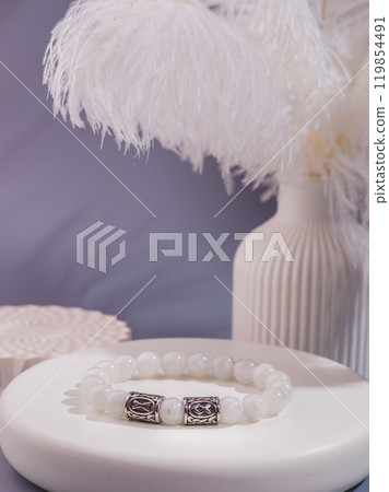 Woman's wrist wearing orange agate bracelet, isolated on white background. Woman's wrist wearing orange agate bracelet, isolated on white background. 119854491