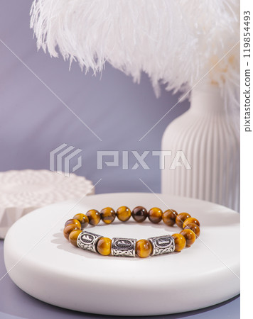 Woman's wrist wearing orange agate bracelet, isolated on white background. Woman's wrist wearing orange agate bracelet, isolated on white background. 119854493