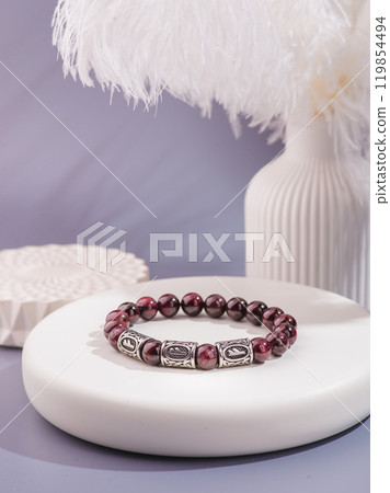Woman's wrist wearing orange agate bracelet, isolated on white background. Woman's wrist wearing orange agate bracelet, isolated on white background. 119854494