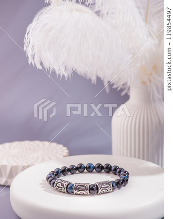 Woman's wrist wearing orange agate bracelet, isolated on white background. 119854497