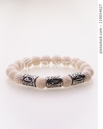 A charming double bracelet in shades of pink, made from natural stone and set against a gray background. The heart charm with cubic zirconia stands out in this close-up top view A charming double bracelet in shades of pink, made from natural stone and set against a gray background. The heart charm with cubic zirconia stands out in this close-up top view 119854627
