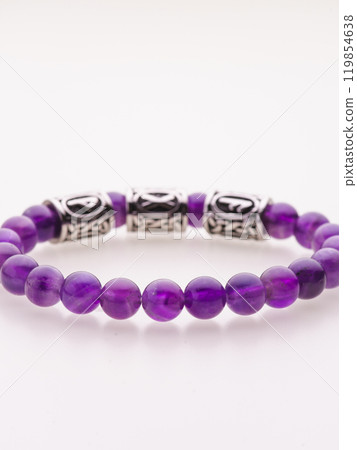 A charming double bracelet in shades of pink, made from natural stone and set against a gray background. The heart charm with cubic zirconia stands out in this close-up top view A charming double bracelet in shades of pink, made from natural stone and set against a gray background. The heart charm with cubic zirconia stands out in this close-up top view 119854638