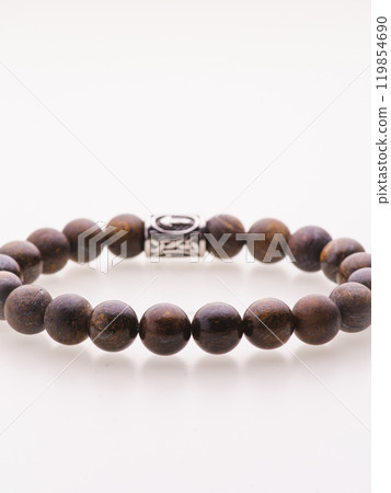 A charming double bracelet in shades of pink, made from natural stone and set against a gray background. The heart charm with cubic zirconia stands out in this close-up top view 119854690