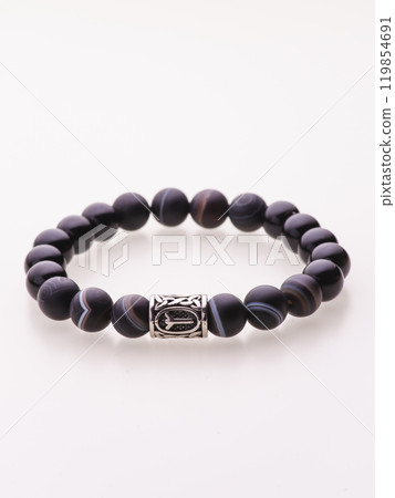 A charming double bracelet in shades of pink, made from natural stone and set against a gray background. The heart charm with cubic zirconia stands out in this close-up top view 119854691