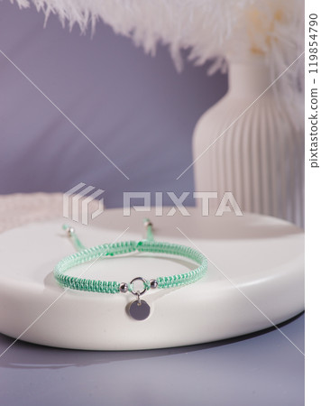Woman's wrist wearing orange agate bracelet, isolated on white background. Woman's wrist wearing orange agate bracelet, isolated on white background. 119854790