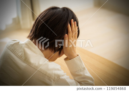 Middle-aged to senior woman holding her head 119854868