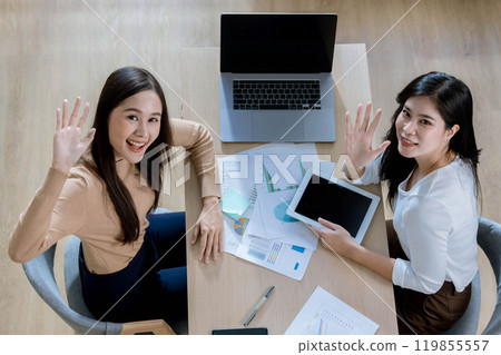 Team of partners Asian business woman discussing project on laptop sitting at table in office. Two colleagues of professional business people working together. 119855557
