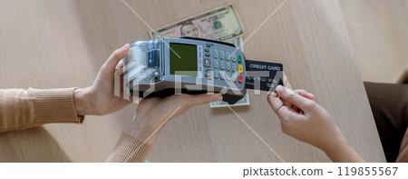 Customer using credit card for payment to receptionist. cashless technology and credit card payment concept. Owner In Retail Shop With Customer Paying Using Payment Credit Card 119855567