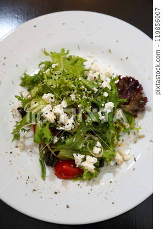 Salad with feta cheese. Salad with cheese, tomatoes and herbs. 119856907