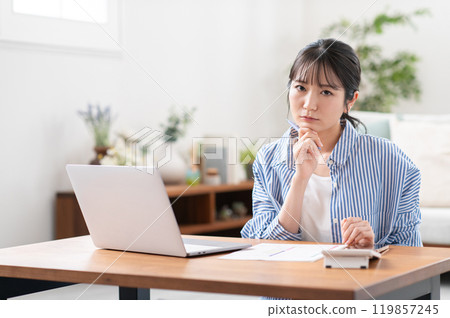 A young woman worried about preparing her tax return 119857245