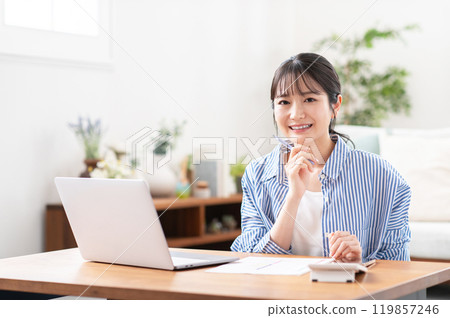 A smiling young woman preparing to file her tax return 119857246