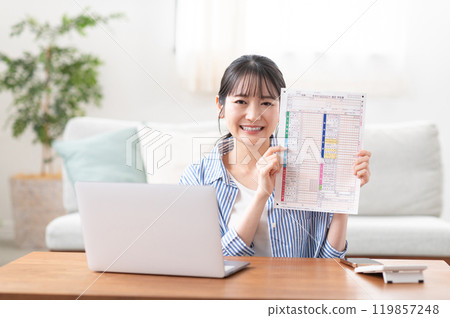 A smiling young woman preparing to file her tax return 119857248