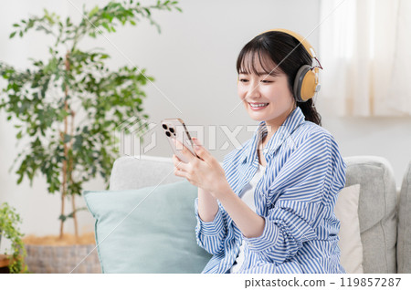 在客廳裡聽音樂的年輕女人 119857287