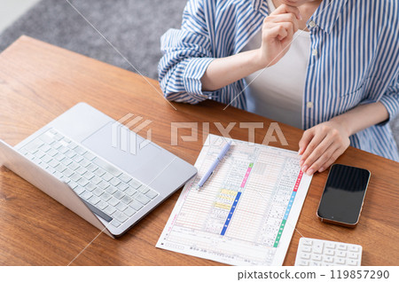 The hands of a young woman preparing to file a tax return 119857290