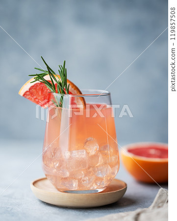 Homemade grapefruit lemonade with rosemary and ice in a glass on a blue background with fresh citrus Homemade grapefruit lemonade with rosemary and ice in a glass on a blue background with fresh citrus 119857508