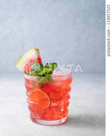 Mojito drink with watermelon, lime, ice and mint in a glass on a light background. Mojito drink with watermelon, lime, ice and mint in a glass on a light background. 119857525