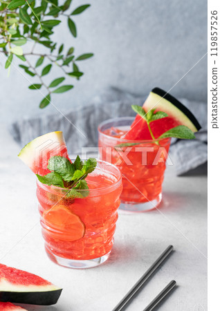 Watermelon mojito cocktail with lime, ice and mint in a two glasses on a blue background Watermelon mojito cocktail with lime, ice and mint in a two glasses on a blue background 119857526