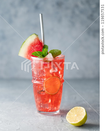 Fresh mojito cocktail with watermelon juice, lime, ice and mint in a glass on a blue background 119857531