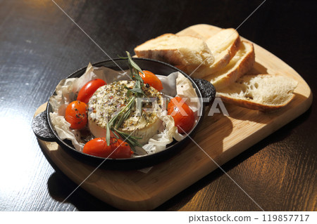 Grilled Camembert. Grilled Camembert cheese with tomatoes and bread. 119857717