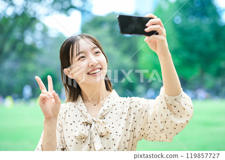 A young lady shooting on a smartphone 119857727