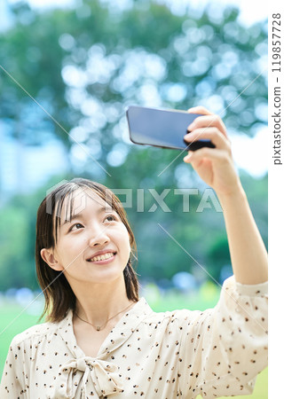 A young lady shooting on a smartphone 119857728