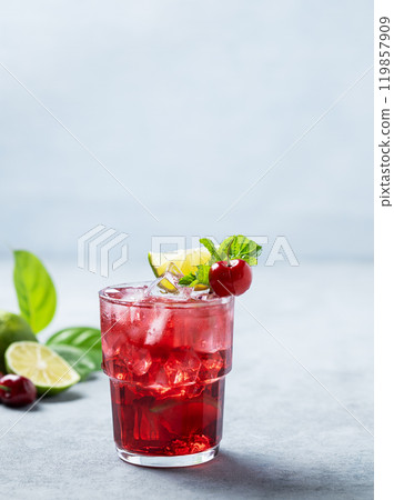 Cherry-lime mojito cocktail with mint, lime and ice on a blue background. Cherry-lime mojito cocktail with mint, lime and ice on a blue background. 119857909