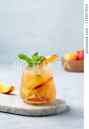 Refreshing peach cocktail, lemonade or iced tea on a marble board on a light background. 119857914