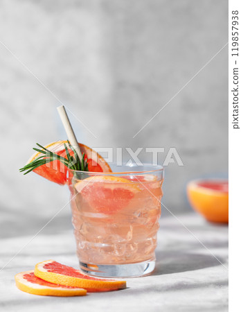 Grapefruit mojito cocktail with rosemary and ice in a glass on a light background Grapefruit mojito cocktail with rosemary and ice in a glass on a light background 119857938