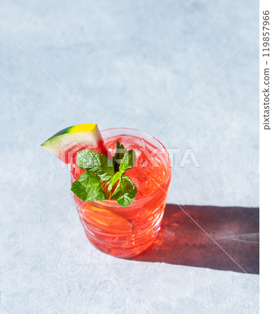 Mojito drink with watermelon, lime, ice and mint in a glass on a light background with shadow. Mojito drink with watermelon, lime, ice and mint in a glass on a light background with shadow. 119857966