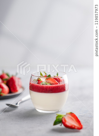 Panna cotta with strawberry and cream in glass with fresh berries on a light background close up  119857973