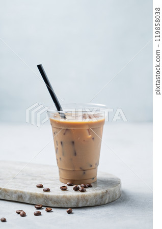 Iced coffee latte in a recyclable plastic glass with milk and ice on a marble board Iced coffee latte in a recyclable plastic glass with milk and ice on a marble board 119858038