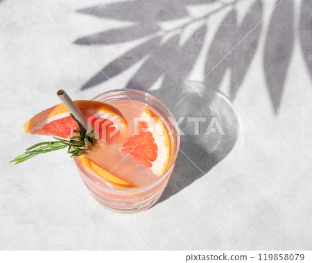 Grapefruit mojito cocktail with rosemary and ice in a glass on a light background  119858079