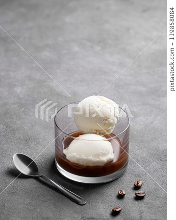 Affogato coffee with vanilla ice cream scoops and espresso in a glass on a dark background 119858084