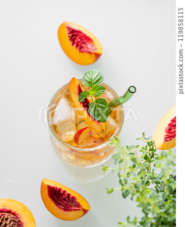 Peach lemonade with ice and mint on white background close up. Fresh iced tea in a glass Peach lemonade with ice and mint on white background close up. Fresh iced tea in a glass 119858115