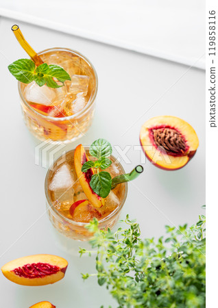 Peach lemonade with ice and mint on white background. Fresh iced tea in glasses  119858116