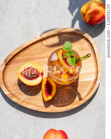 Peach lemonade with ice and mint on a wooden board on a concrete background. Fresh iced tea Peach lemonade with ice and mint on a wooden board on a concrete background. Fresh iced tea 119858119