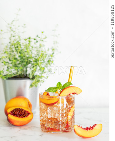 Peach refreshing drink with ice and mint on marble background. Fresh homemade lemonade in a glass Peach refreshing drink with ice and mint on marble background. Fresh homemade lemonade in a glass 119858125