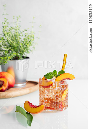 Peach refreshing drink with ice and mint on a white background. Fresh homemade lemonade in a glass  119858129