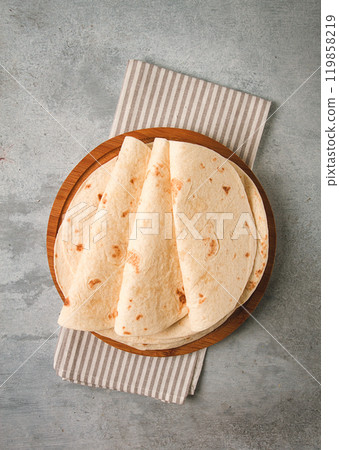 A stack of Mexican tortillas, on a gray table, top view, close-up, no people, 119858219