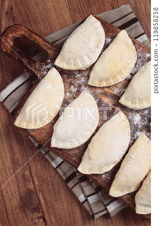 Traditional Polish dish, dumplings , raw, frozen, on a cutting board, wooden table, top view, no people, 119858258