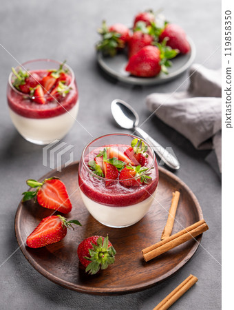 Strawberry and cream panna cotta in glasses with fresh berries on a wooden plate  119858350