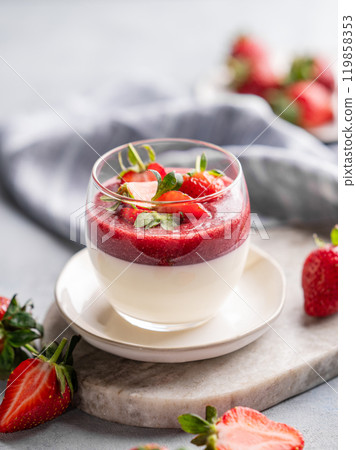 Panna cotta with strawberry and cream in glass with fresh berries on a marble board 119858353